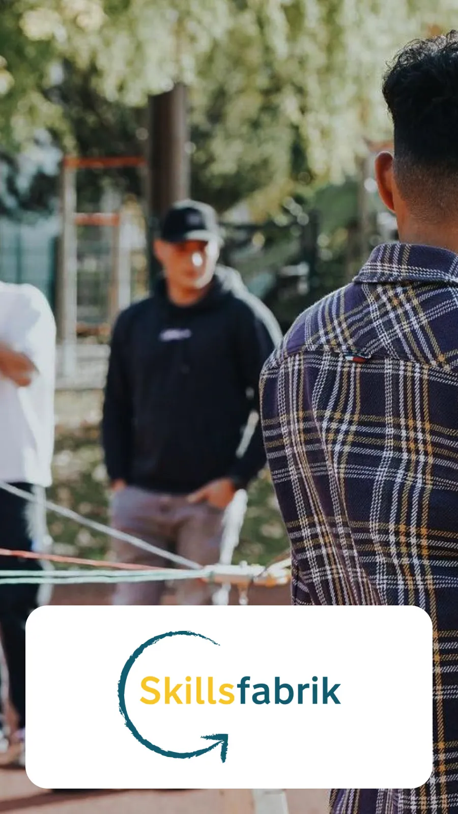 Outdoor-Teamaktivität mit mehreren Personen und einem Netzwerk aus Schnüren. Im Vordergrund das Logo der "Skillsfabrik" mit Pfeilsymbol.